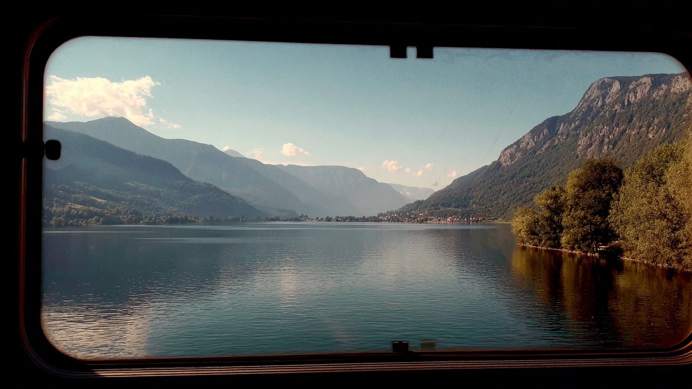 Вид из окна поезда, озеро и горы